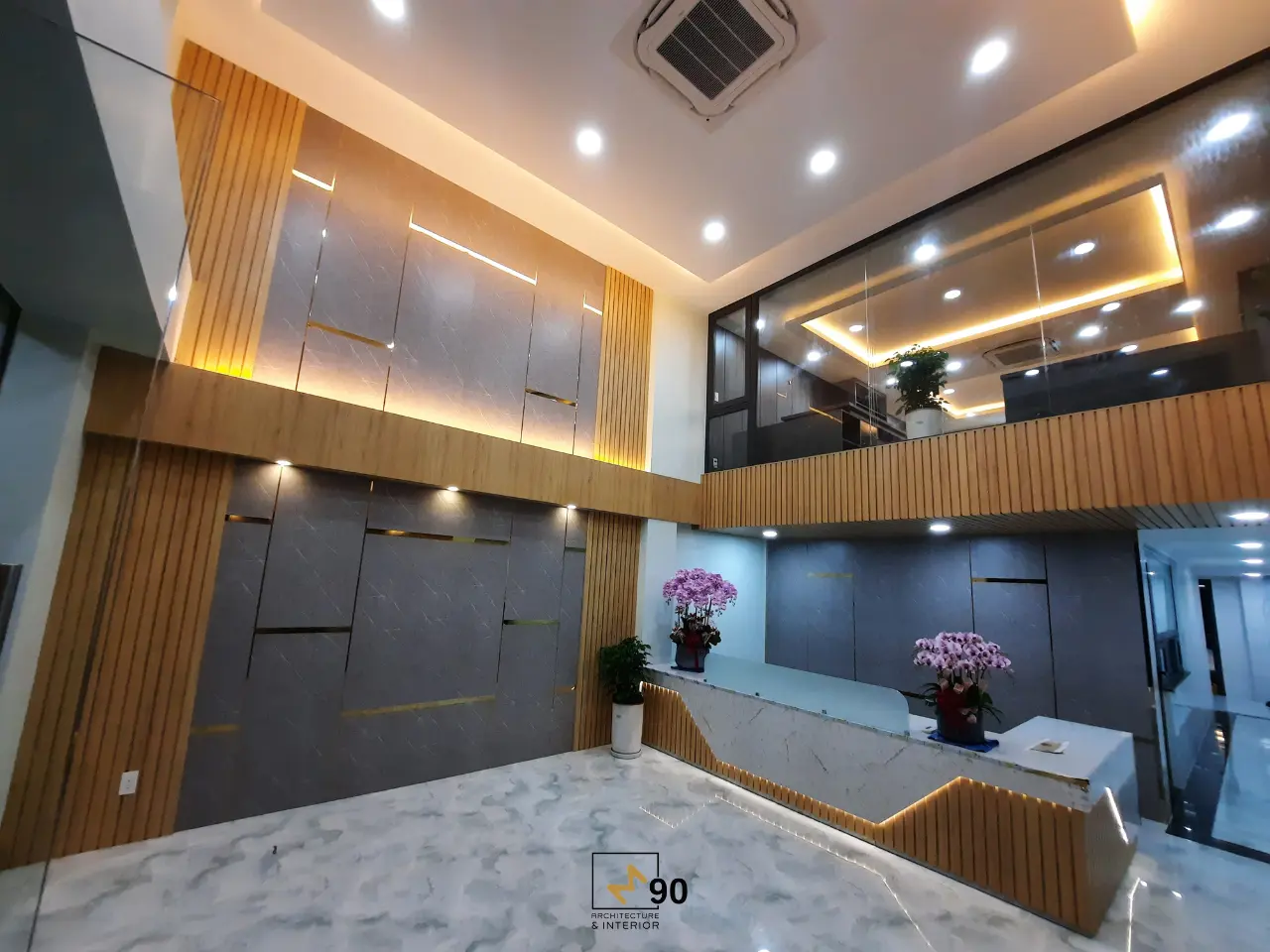 Sảnh tiếp khách văn phòng với thiết kế sang trọng, trần cao và hệ đèn hiện đại