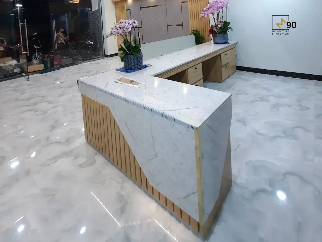 Quầy lễ tân văn phòng hiện đại với thiết kế tối giản, vật liệu cao cấp và ánh sáng tinh tế